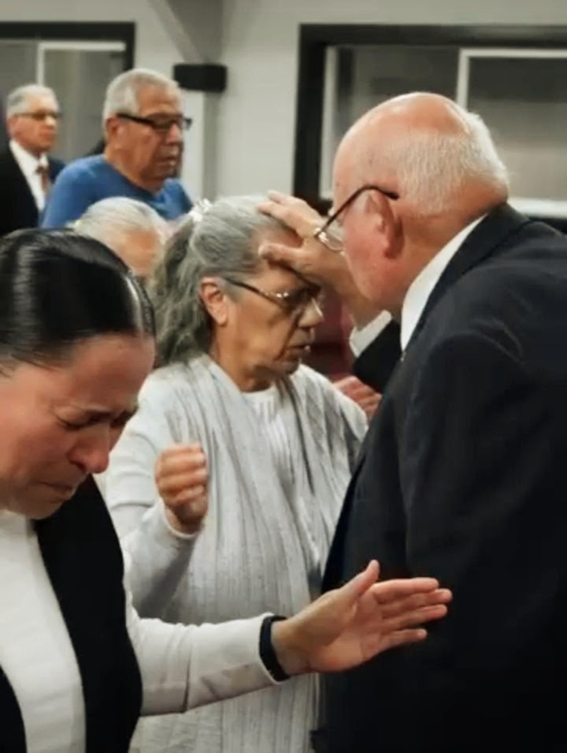 Ministers standing together, laying hands and praying over a sister