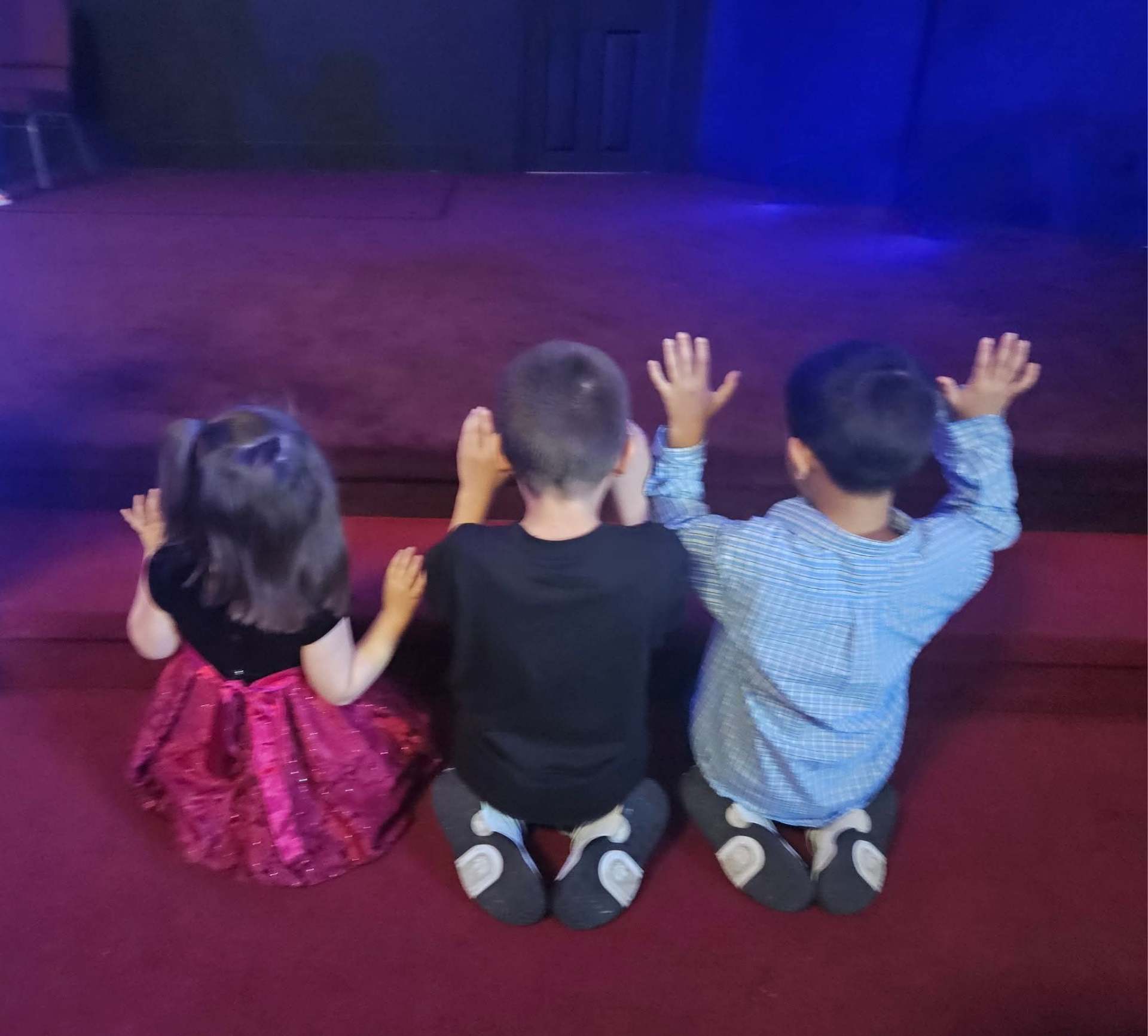 Children kneeling and praying at the altar
