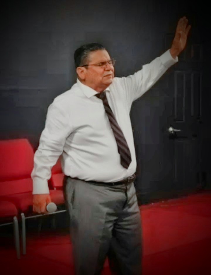 A minister worshipping with his hand raised during service